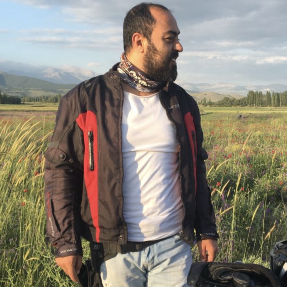 Can Yastıoğlu, motosiklet montuyla bir çiçek tarlasında